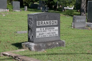 The gravestone of Ruben Bransonis readily visible driving by the NW corner of Oklahoma and Commercial Steets in historic downtown Branson. 